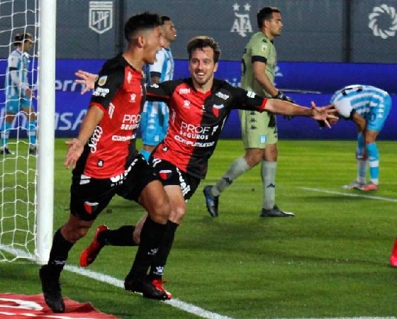 Aliendro celebra el primer gol de Colón, mientras sufre Racing.