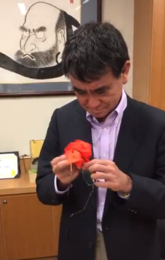 Ministro de Defensa de Japón realiza una grulla de origami en segundos con el paño de sus lentes
