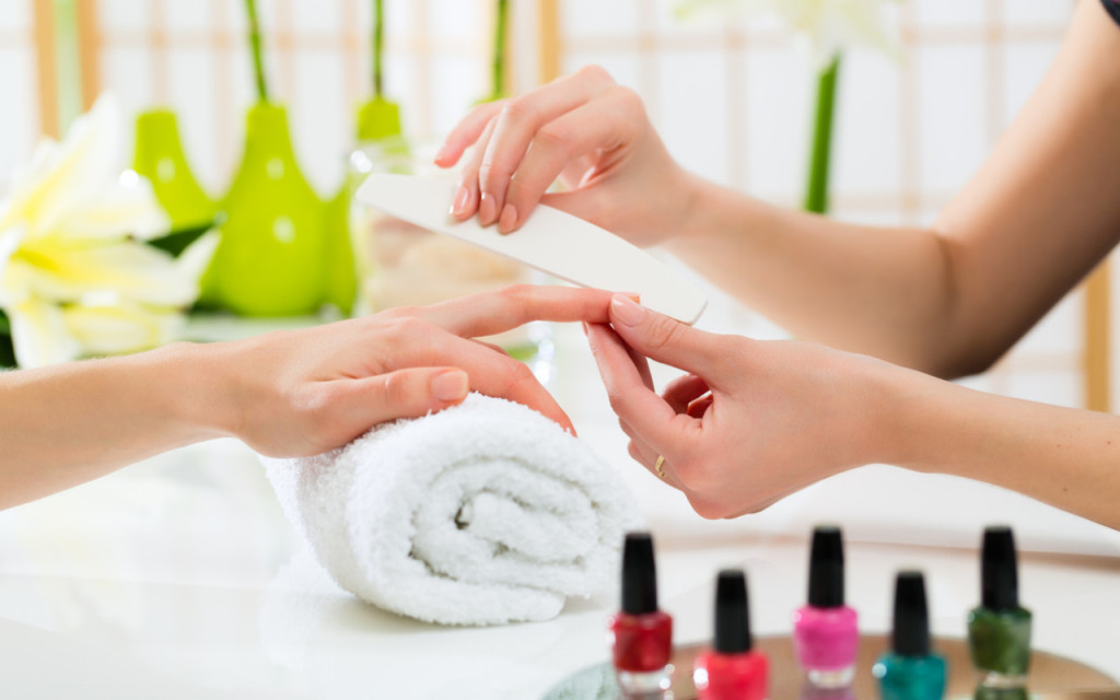 Woman in nail salon receiving manicure