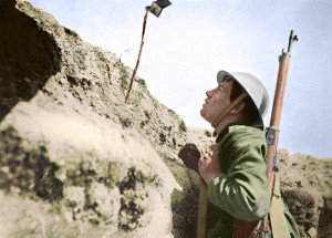 A sentry in the trenches looking through an improvised periscope at the Somme.