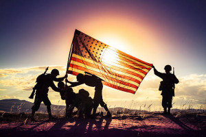 WWII Soldiers Raising The American Flag At Sunset.