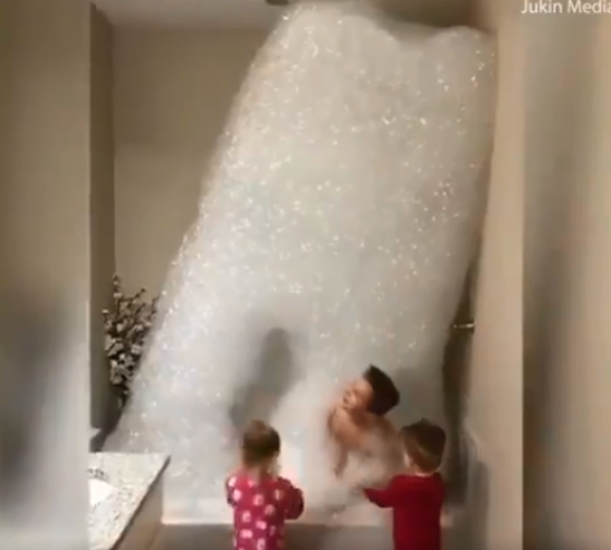 Cuatro niños juegan con montaña de burbujas cuando están al cuidado de su papá , sin su madre. 