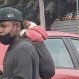 Joven conmueve en TikTok al limpiar parabrisas en la calle mientras carga a su perrito en la espalda
