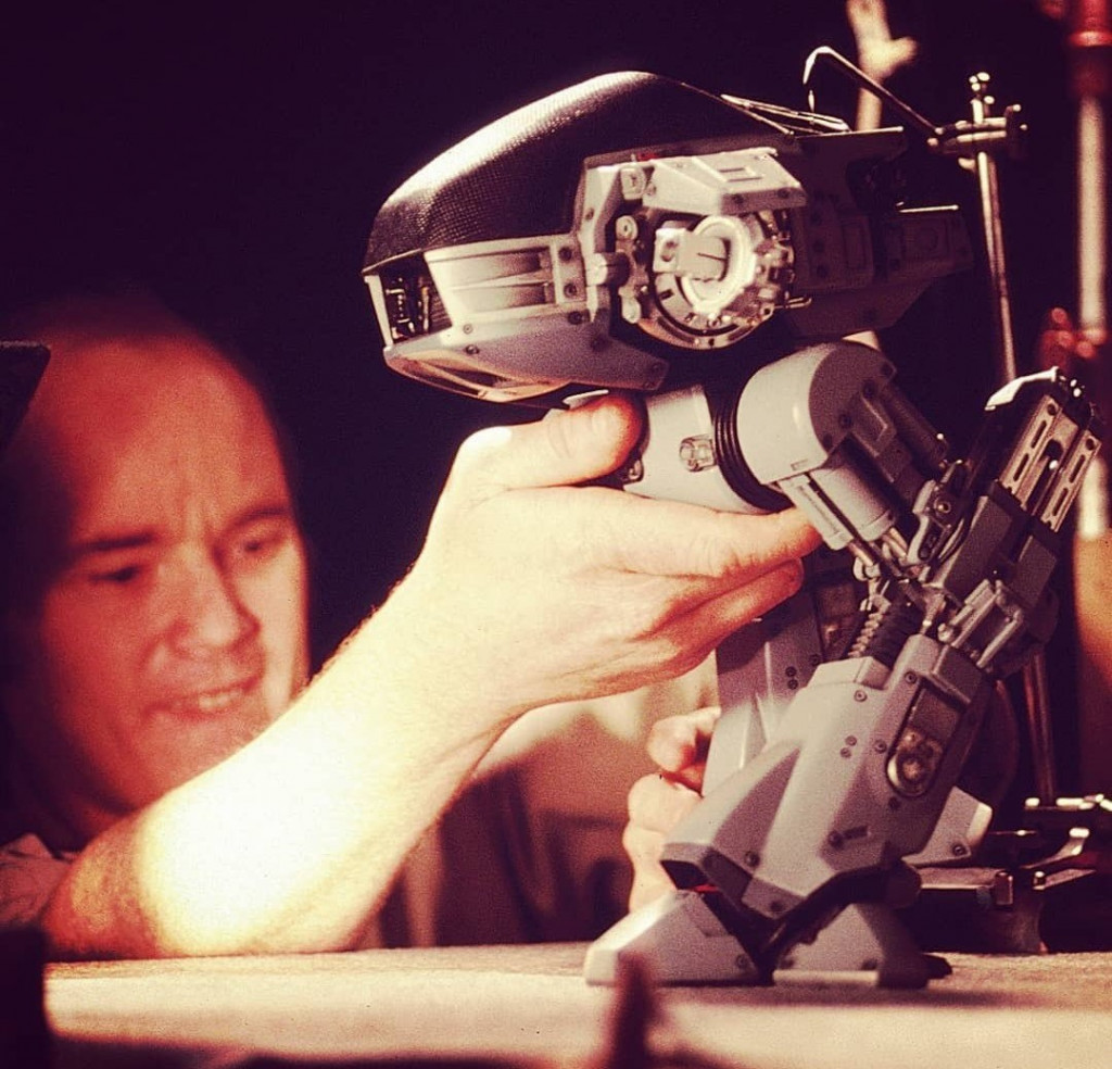 Phil Tippett, uno de los encargados de los efectos especiales de Robocop, junto a un pequeño modelo a escala del robot ED-209.
