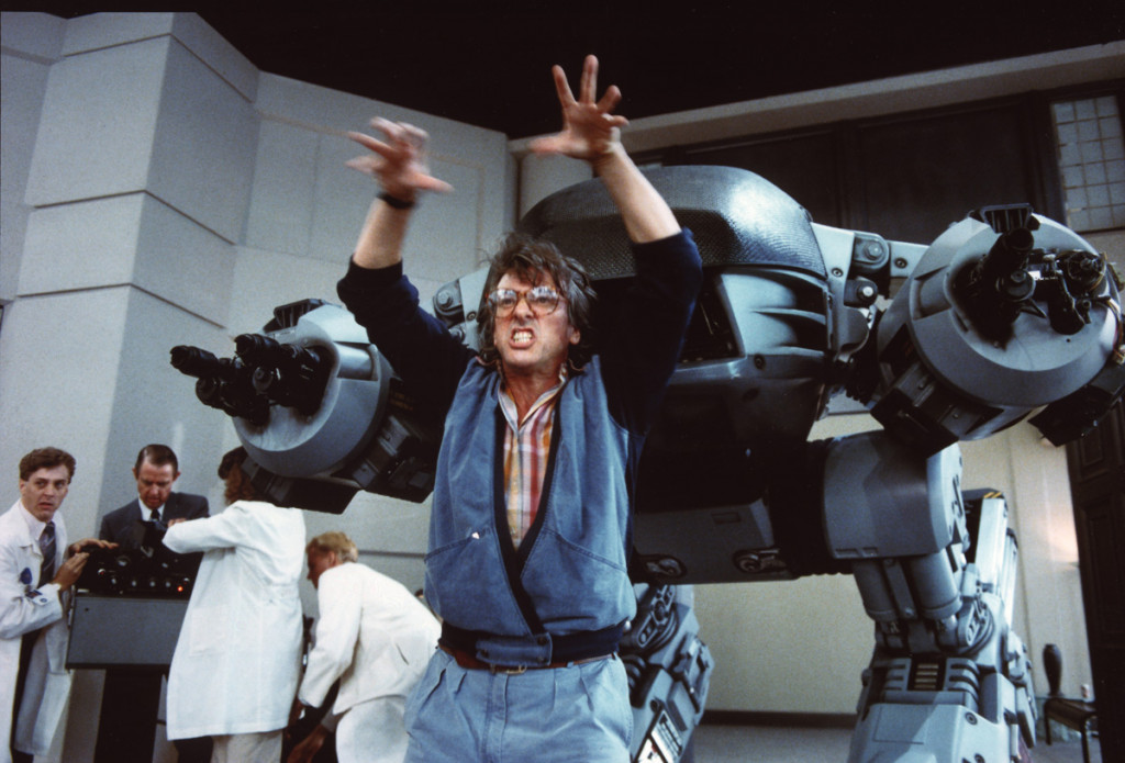 El director Paul Verhoeven al lado de una réplica del robot E D-209, haciendo unos divertidos gestos al equipo de filmación.