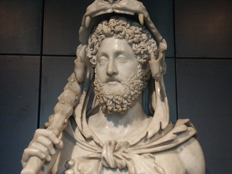 Busto del emperador Cómodo, ataviado con un arma y una cabeza de un animal salvaje sobre su cabeza.