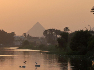 The Pyramid of Khufu, the largest of the Great Pyramids of Giza, is seen behind a canal which flows into the River Nile on the outskirts of Cairo