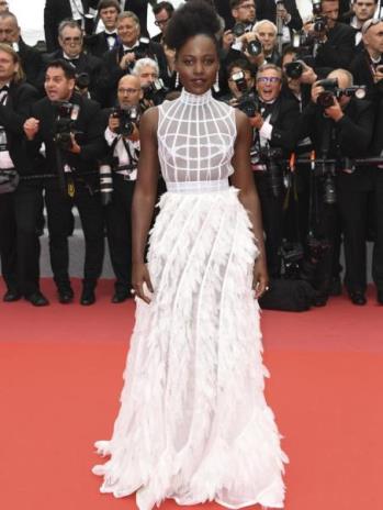 6.- La actriz Lupita Nyong'o desfiló por Cannes con un diseño blanco de Dior, con plumas y efecto corsé transparente.