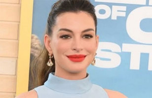 Anne Hathaway revoluciona la moda premam&aacute; usando este inesperado look con un atrevido top corto y jeans